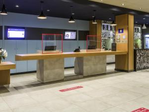a lobby with a large counter with two mirrors at Ibis Americana in Americana