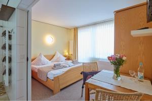 a hotel room with a bed and a table at Strandwetter Dünenhotel in Borkum