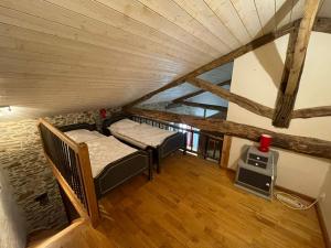 an attic room with two beds and a stove at Maison d'hôtes la Passemarié in Andouque