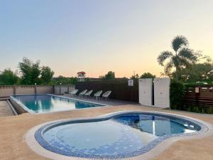 a swimming pool with chairs in a backyard at Lueangchan Orchid Hotel in Chanthaburi