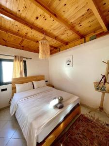 a bedroom with a large bed with a wooden ceiling at Arinas Surf Hostel in Taghazout