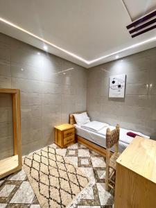 a bedroom with a bed and a table in it at Arinas Surf Hostel in Taghazout