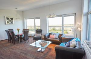 a living room with a couch and a table at Strandwetter Dünenhotel in Borkum