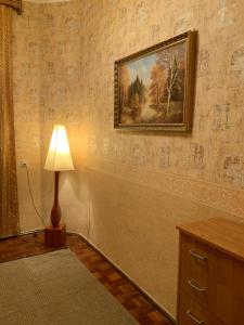 a lamp in a room with a painting on the wall at Український Театр 2-х кімнатні Апартаменти in Odesa