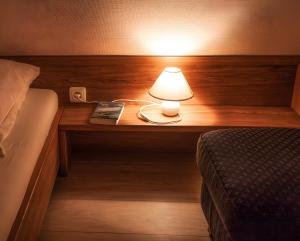 a lamp on a table next to a bed at Haus Nordmarsch in Langeneß