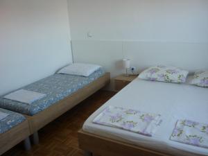 a bedroom with two beds and a table with a lamp at Jelena i Agi apartman Bibinje in Bibinje
