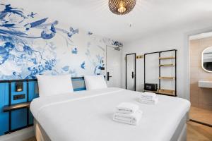 a bedroom with a large white bed with towels on it at Dutch Design Hotel Vondelpark in Amsterdam