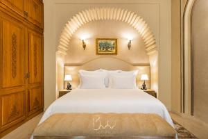 a bedroom with a white bed with an arch above it at Sillage Palace Sky & Spa in Marrakesh +194 photos