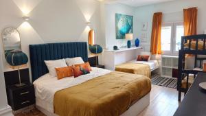 a bedroom with a bed with a blue headboard at Villa Whiteloft Pool Spa Lounge in Corroios +50 photos