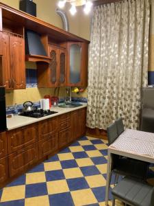 a kitchen with wooden cabinets and a checkered floor at Український Театр 2-х кімнатні Апартаменти in Odesa