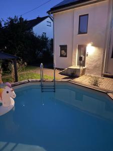 a swimming pool in front of a house at Unger's Ferienwohnung Mariella in Isny im Allgäu