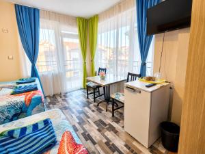 a small room with a kitchen and a table with a refrigerator at Kazlarov Guest House in Kiten