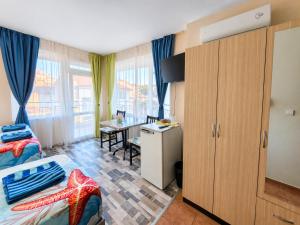 a bedroom with a bed and a desk in a room at Kazlarov Guest House in Kiten