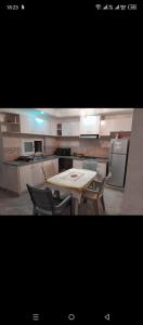 a kitchen with a table and two chairs and a table and a kitchen at Jouini tasyif in Kelibia