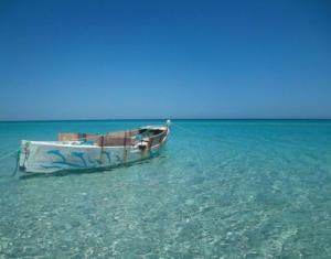 a boat sitting in the water in the ocean at Jouini tasyif in Kelibia