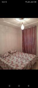 a bedroom with a bed with a red curtain at Jouini tasyif in Kelibia