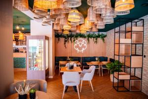 a restaurant with tables and chairs and chandeliers at Mliečna víla in Turčianske Teplice