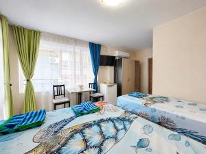a bedroom with two beds and a dining room at Kazlarov Guest House in Kiten