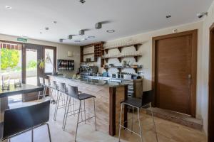 a kitchen with a bar with stools at La Posada del Vencejo in Alles