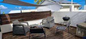 a group of chairs and a grill on a deck at Tite Case Désirée in Petite Île