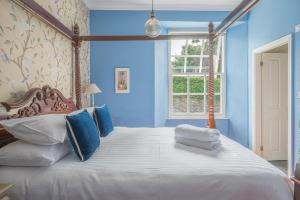 a bedroom with a large bed with blue walls at Lonsdale House in Bowness-on-Windermere