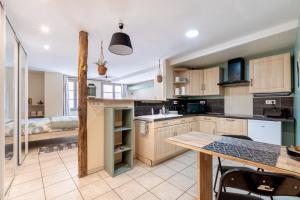 a kitchen with wooden cabinets and a dining table at La suite de L'Evêché in Limoges