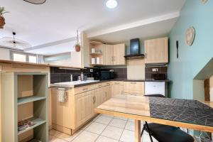 a kitchen with wooden cabinets and a wooden table at La suite de L'Evêché in Limoges +6 photos