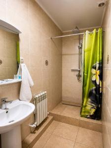 a bathroom with a sink and a shower with a shower curtain at Baiterek Resort in Karagandy +30 photos