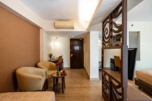 a hotel room with a bed and a living room at Atanaya Kuta Bali in Kuta