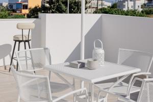 a white table and chairs on a balcony at NEP APT Gennadi in Gennadi