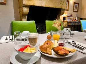 a table with a plate of food and a bowl of fruit at Teritoria Hôtel Wilson in Dijon