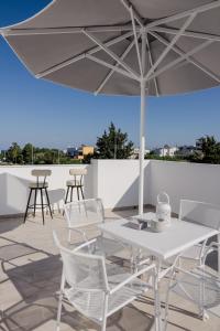 a table and chairs and an umbrella on a roof at NEP APT Gennadi in Gennadi