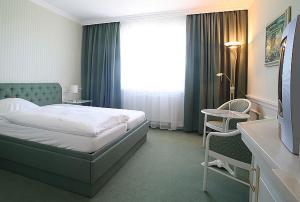 a hotel room with a bed and a television at Pension Schererhof in Pliening