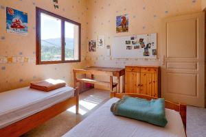 ein Schlafzimmer mit zwei Betten, einem Schreibtisch und einem Fenster in der Unterkunft Gite 07 in Privas