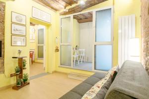 a living room with a couch and large windows at CozyBricks in Lucca - Apartments in the Historical Center - in Lucca