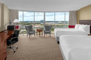 a hotel room with two beds and a desk and chairs at Four Points by Sheraton Orlando International Drive in Orlando +43 photos