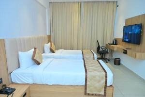 a hotel room with two beds and a television at BHAVANIS Vista By ICON in Hosūr +86 photos