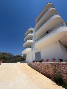 a white building with potted plants on the side of it at Villa Er Deti in Sarandë