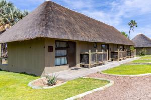 a building with a thatched roof with a grass at Palmwag Lodge in Palm +17 photos