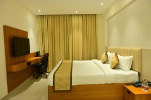 a hotel room with a bed and a television at BHAVANIS Vista By ICON in Hosūr