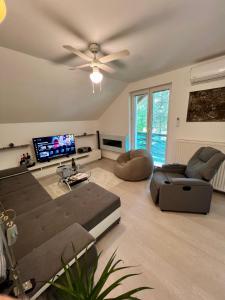 a living room with a couch and a ceiling fan at Quiet Forest Retreat with Pool in Borovnica