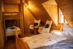 a bedroom with a bed and two chairs in a cabin at Chata Svahovka in Malá Morávka
