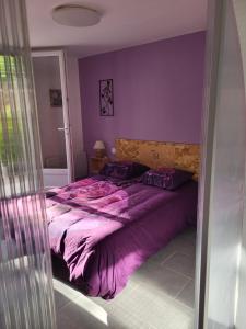a purple bedroom with a large bed with purple sheets at Paisible T2 climatisé avec jardinet in Béziers
