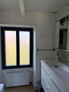 a bathroom with a large sink and a window at La jolie maison en grès rouge in Lagleygeolle +19 photos