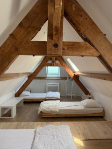 a bedroom with two beds in a attic at La jolie maison en grès rouge in Lagleygeolle