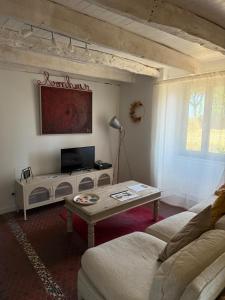a living room with a couch and a coffee table at La jolie maison en grès rouge in Lagleygeolle