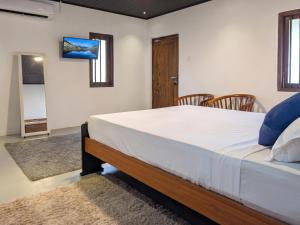 a bedroom with a large bed with blue pillows at The Loons Lake Villa in Tangalle