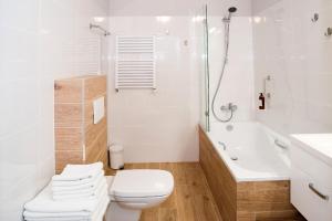 a white bathroom with a toilet and a shower at Apartamenty 107 in Rumia +12 photos