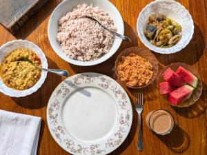 a table with plates of food and bowls of food at The Loons Lake Villa in Tangalle