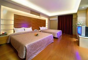 a hotel room with two beds and a flat screen tv at 華倫汽車旅館 in Erlin
